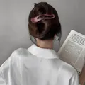 Matte wine red hair clip with elegant cutout design styled in a ponytail bun - Rose Red