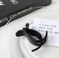 Minimalist matte black claw clip for women featuring a sleek cross-arch design and inner teeth - Black (Matte)