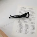 Minimalist matte black banana hair clip displayed on vintage book page background - Black (Banana Shape)