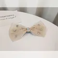 Elegant champagne organza bow hair clip featuring sparkling zircon stones and a center crystal - Organza Bow With Rhinestone / Champagne