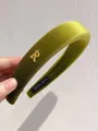 Dettaglio del cerchietto in velluto verde avocado con lettera R dorata e etichetta handmade - Cerchietto / Verde