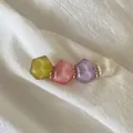 Barrette à cheveux avec perles géométriques pastel et anneaux dorés sur tissu blanc - Color Block