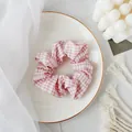 Roze en witte ruitjes scrunchie gepresenteerd op een minimalistisch decoratief porseleinen bord - Haarelastiek / Roze