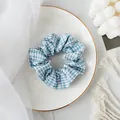 Blauwe gingham stoffen scrunchie op een porseleinen bord voor herfstige haarstijlen - Haarelastiek / Blauw