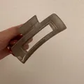 Dettaglio di una grande pinza per capelli rettangolare in acrilico grigio fumo - Grigio