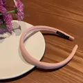 Chic padded pink sponge headband for women with a handmade label on a white ceramic plate - Pink