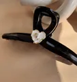Macro detail of French style black hair claw clip featuring a golden rose heart motif - White Rose Heart