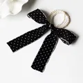 Detail of elegant black polka dot satin bow hair tie with luxury faux pearl elastic band - Black