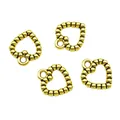 Detailed view of four vintage golden alloy heart charms with textured edges for DIY jewelry - Antique Gold