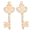 Macro shot of two vintage golden key pendants with intricate European scroll patterns - KC Gold