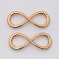 Macro view of infinity-shaped rose gold alloy jewelry connectors for DIY jewelry making - KC Gold