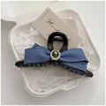 Dettaglio di fermaglio per capelli in denim con fiocco, rosa nera e perle su sfondo bianco - Blu scuro