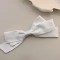Eleganter großer weißer Satin-Haarclip mit seidigem Finish auf minimalistischem Hintergrund - Weiß