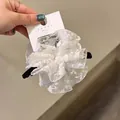 Détail d'un chouchou géant en dentelle blanche avec texture de tissu multicouche élégante - Pince à cheveux / Blanc