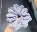 Detail van lavendelkleurige kanten scrunchie met witte parels en Seoul-oorsprongstag - Blauw