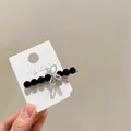 Dettaglio del fermaglio coreano con perline nere e fiocco d'argento scintillante - Clip Laterale in Cristallo Nero