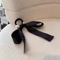Detail van elegante zwarte satijnen haarelastiek met parels op witte achtergrond - Zwart