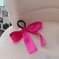 Elegante satijnen haarelastiek met strik in magenta en parels op witte stof - Magenta