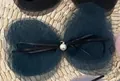 Detailed view of handmade mesh bow hair clip with pearl pendant and black ribbon accent - Dark Green