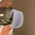Light purple wide braided headband with hollow mesh pattern shown in a hand-held view - Light Purple/Light Blue