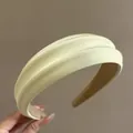 Detail showing the creamy yellow satin texture and padded design of the wide headband - Fruit Green