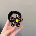 Detail of floral scrunchie with pink pattern, black ruffle band and yellow center button - Small Black Floral