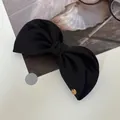 Eleganter schwarzer Stoff-Haarclip mit goldener Metallschnalle auf weißem Grund - Schwarze Bananenspange / Schwarz