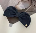 Nahaufnahme der dunkelblauen Denim-Haarschleife mit goldenem Logo und feiner Webstruktur - Denim Bananen-Clip / Denim-Blau
