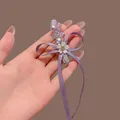 Macro detail of purple ribbon bow hair clip with crystal and handmade metal tag - Taro Purple