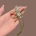 Detail of handmade light green ribbon bow hair clip with crystal beads and white flower - Apple Green