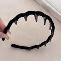 Dettaglio dei denti interni e della texture in velluto nero di questa fascia per capelli - Nero