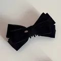 Nahaufnahme einer großen schwarzen Samtschleife-Haarklammer mit goldenem Love-Logo - Schwarz