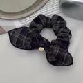 Detalle de coletero de cuadros con lazo y medalla dorada sobre un fondo de estilo retro - Cuadros Azul Marino