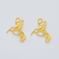 Detailed macro view of two gold-colored hummingbird alloy charms with hollow wings - Gold