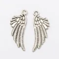 Pair of vintage silver alloy wing charms with detailed feather texture and top hanging loops - Antique Silver