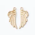 Close-up of golden alloy wing charms with textured feathers and integrated top hanging loop - KC Gold