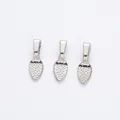Close-up of three silver plated alloy pinch bails with textured teardrop detail for DIY jewelry - White K/Silver