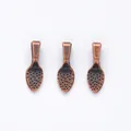Close-up of three vintage bronze teardrop jewelry connectors with textured dot pattern - Antique Red Copper