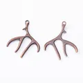 Paire de pendentifs bois de cerf en bronze vintage avec anneaux sur fond blanc - Cuivre rouge antique