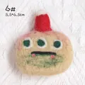Handmade wool felt brooch featuring a beige three-eyed monster with a red holiday hat - Apricot Three-Eyed Red Hat