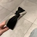 Dettaglio di un cerchietto in raso intrecciato con elegante design color-block nero e beige - Nero