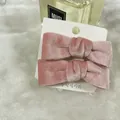 Set of two pink velvet bow hair clips for women on a white display card package - Pink