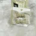 Set of two champagne velvet bow hair clips with pearls on a white display card - Champagne