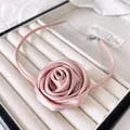 Detailed macro view of pink satin rose choker with silver adjustable metal chain and clasp - Pink