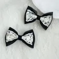 Detail of elegant black and white lace bow hair clips on a delicate lace background - Black