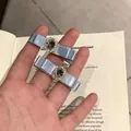 Pair of light blue silk bow hair clips with crystal oval centers on vintage book - Blue