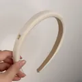 Dettaglio di cerchietto in peluche beige con logo Y in metallo dorato e interno antiscivolo - Bianco