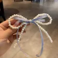 Detalle del pasador para el pelo con perlas blancas y lazo de cinta azul claro - Azul
