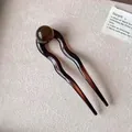 Dettaglio della forcina in resina marrone ambra a forma di U con perla e design a doppia punta - Marrone Tartarugato Perla