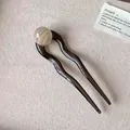 Dettaglio di forcina a U con perla effetto marmo e design a onda in resina marrone - Beige Tartarugato Perla